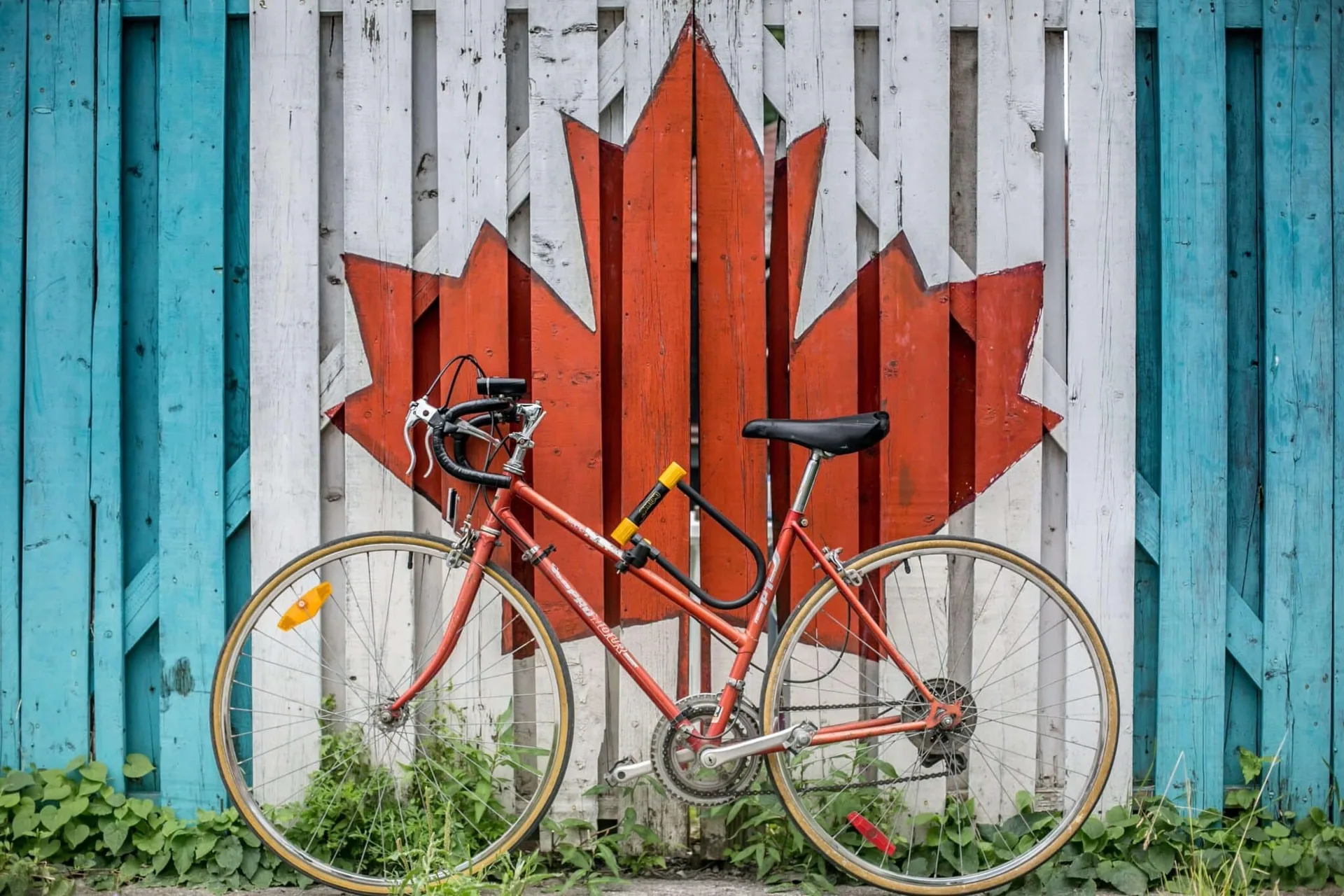 bicicleta em frente à pintura da bandeira canadense