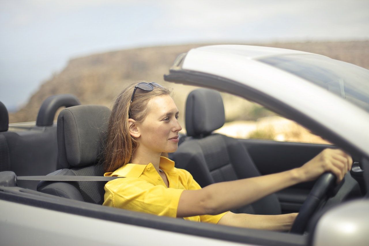 mulher dirigindo carro conversível