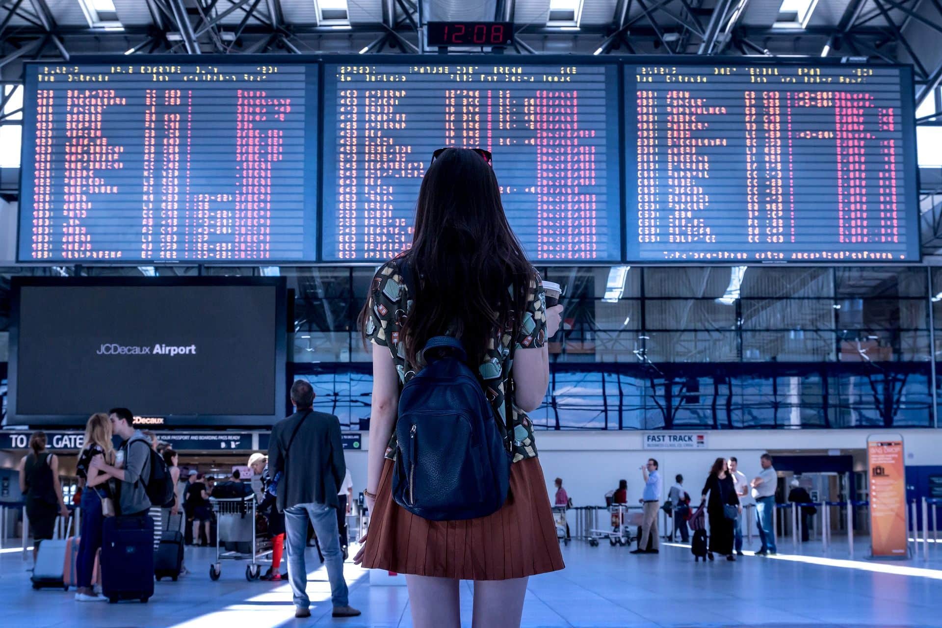 mulher olhando para painel em aeroporto