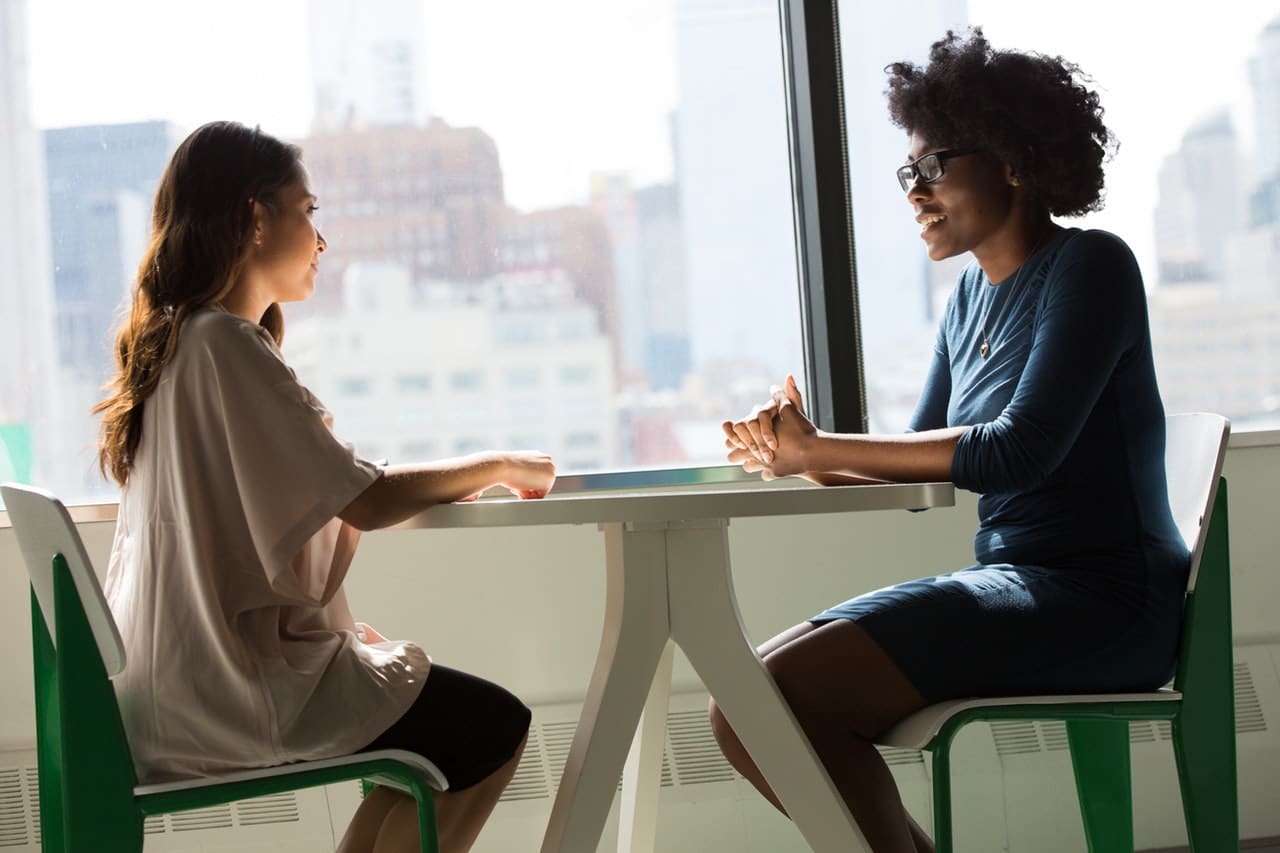 Duas mulheres conversando em uma mesa