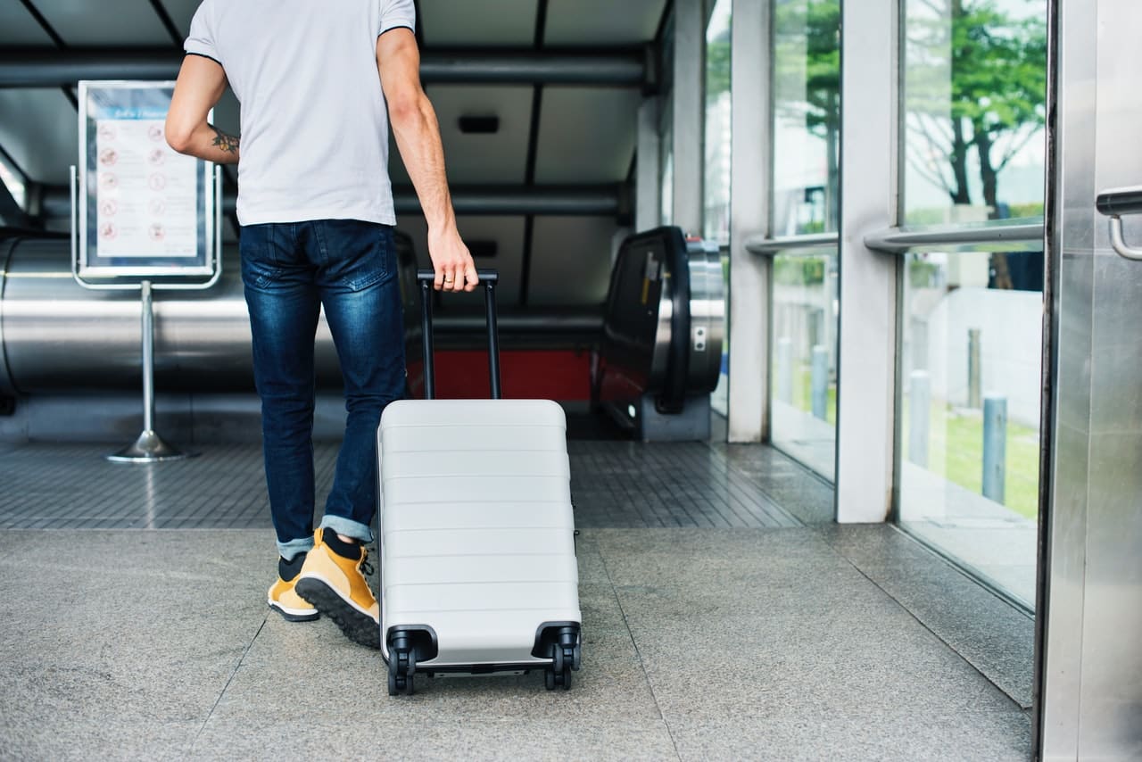 homem com mala em aeroporto internacional